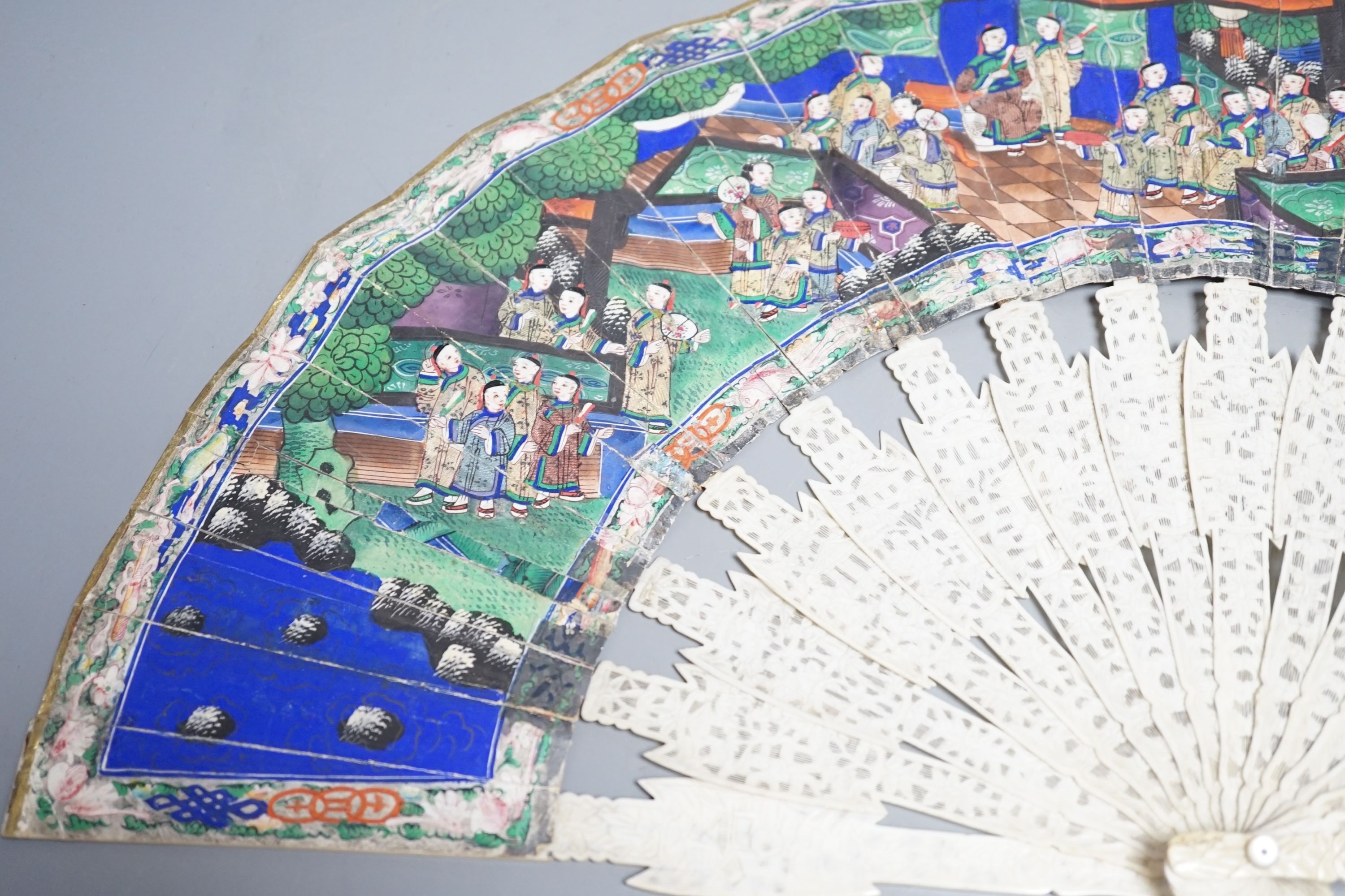 A 19th century Chinese export pierced ivory and painted paper leaf fan, in box. Fan 28cm long